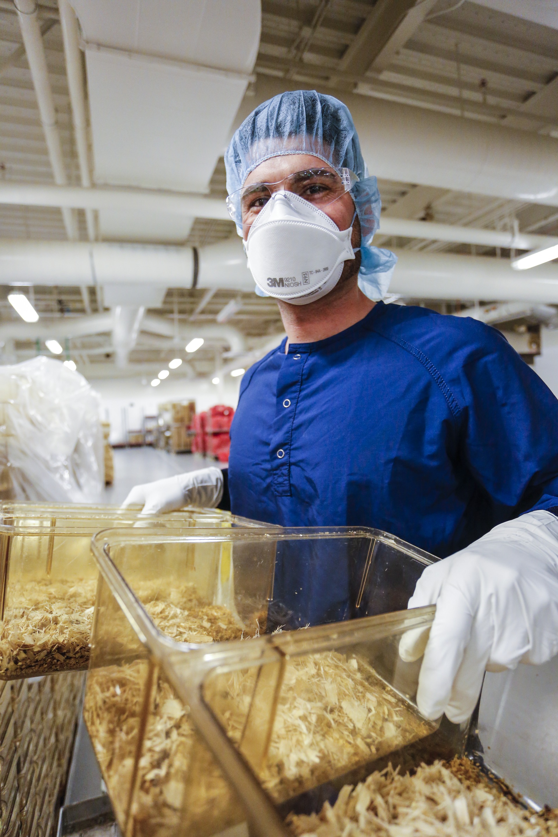 An operations employee loads mouse cages into the tunnel washer the Wash Supply Area (WSA) at JAX West, Sacramento, California.